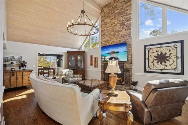 a living room with furniture a chandelier and kitchen view