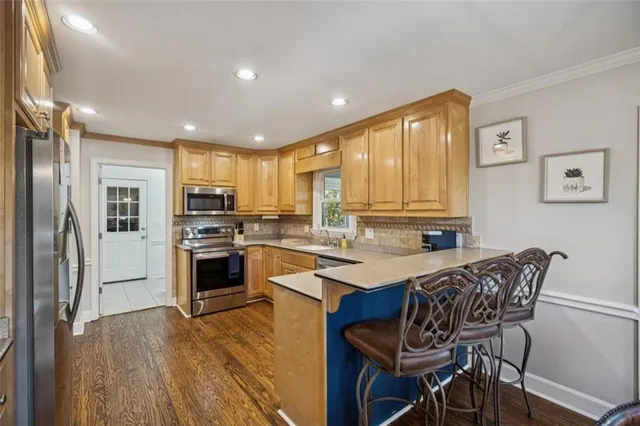 a kitchen with refrigerator a stove and chairs
