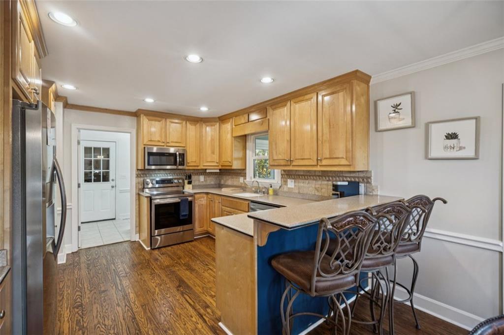 1173 Antioch Campground Road Gainesville, GA 30506 - Photo 7 of 23 a kitchen with refrigerator a stove and chairs