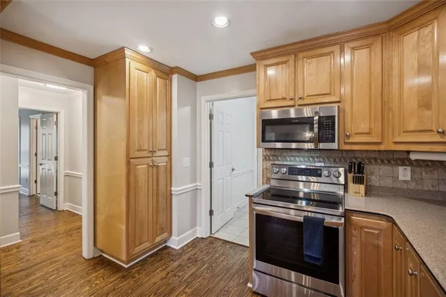 a kitchen with stainless steel appliances a stove a microwave and cabinets
