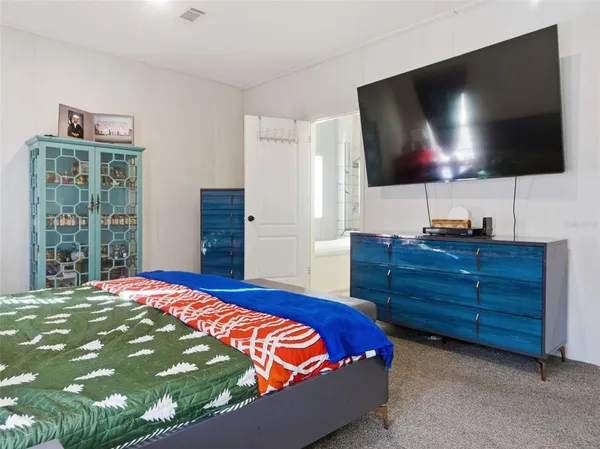 a bedroom with a bed flat screen tv and a window
