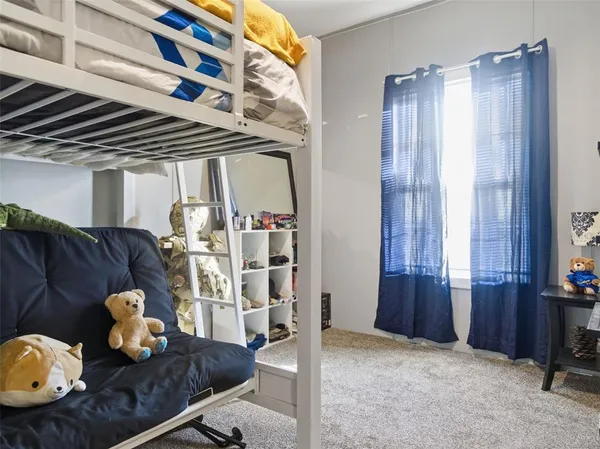 a large bed sitting in a bedroom next to a window