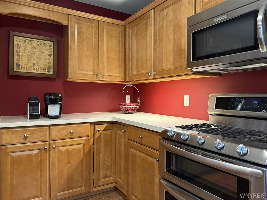 73 Chestnut Lancaster, NY 14086 - Photo 11 of 41 Rich wood cabinetry surrounds integrated stainless steel appliances, creating a highly functional culinary workspace.