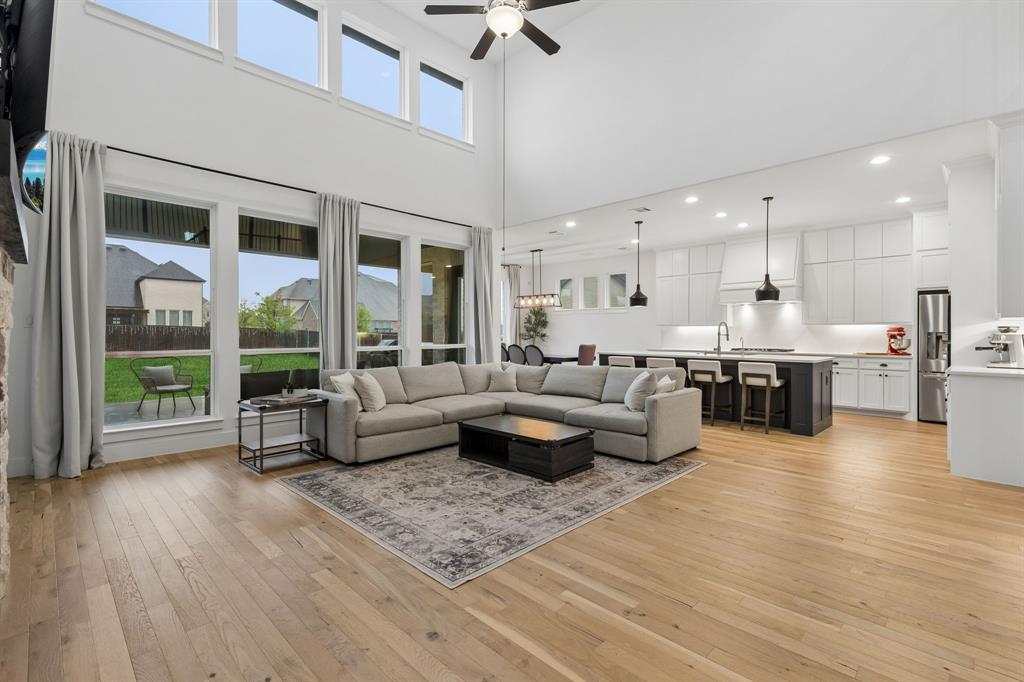566 Broadleaf Way Haslet, TX 76052 - Photo 2 of 38 Open-concept living space featuring high ceilings, wood-finish flooring, and extensive natural light from multiple windows