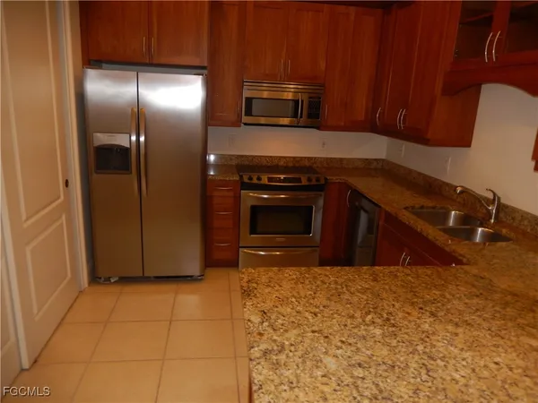 a kitchen with granite countertop a stove and a refrigerator