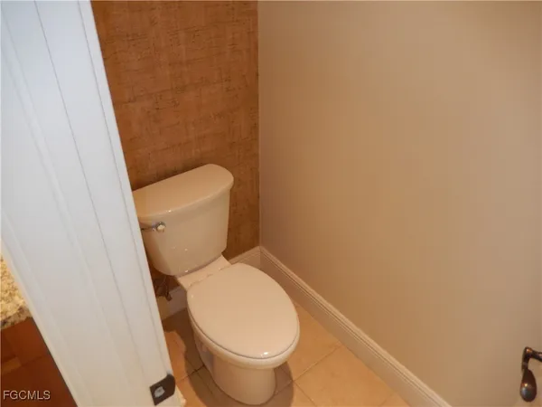 a white toilet sitting next to a white wall
