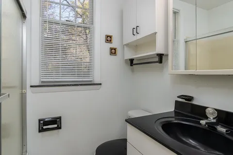 a bedroom with a bed a table and painting on the wall