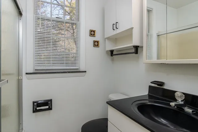a bedroom with a bed a table and painting on the wall