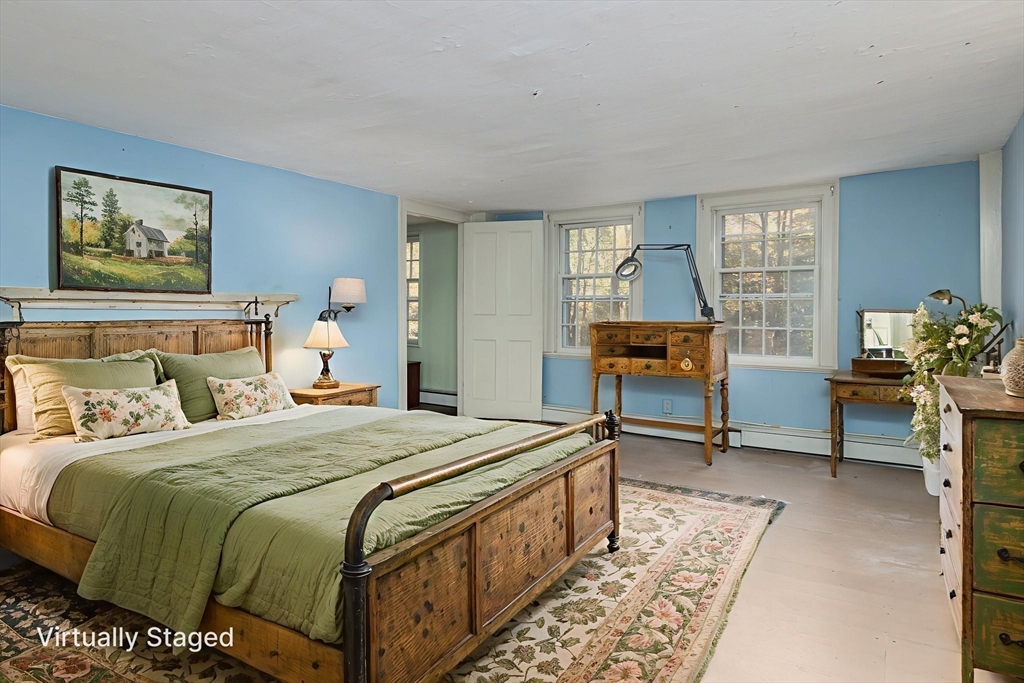 436 Main Street Groton, MA 01450 - Photo 23 of 39 a bedroom with a bed a table and painting on the wall