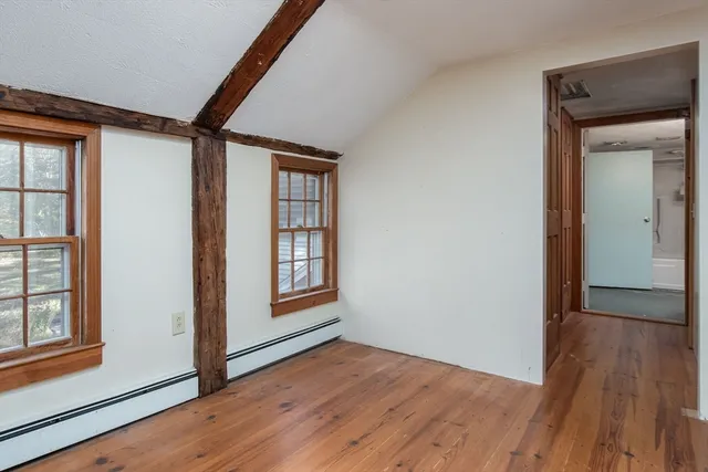 a view of a hallway with wooden floor and cabinet