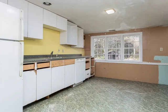 a view of an empty room with window and cabinet