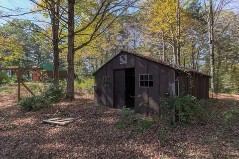 a yellow house in middle of the forest