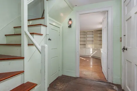 a view of a hallway with wooden floor and staircase