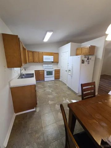 a room with a table chairs and a refrigerator