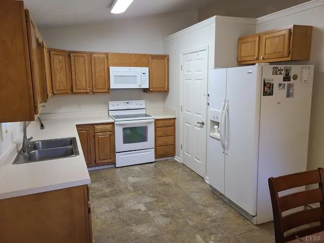 a kitchen with stainless steel appliances granite countertop a refrigerator a sink dishwasher a stove with wooden cabinets