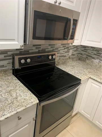 a stove top oven sitting inside of a kitchen