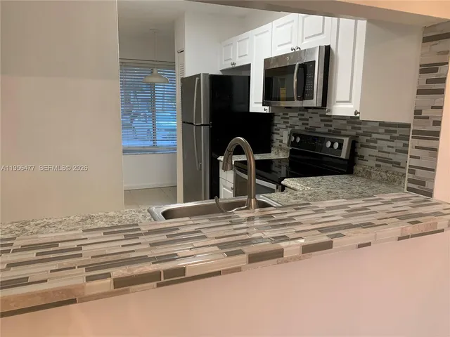 a kitchen with stainless steel appliances a stove microwave and refrigerator