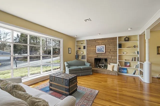 a living room with fireplace furniture and a large window