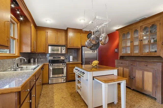 a kitchen that has a lot of cabinets in it and stainless steel appliances