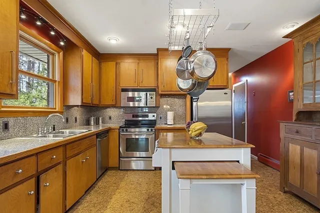 a kitchen with stainless steel appliances granite countertop a sink a stove and refrigerator
