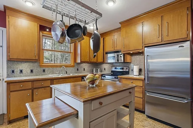 a kitchen with a sink stainless steel appliances granite countertop a sink and cabinets