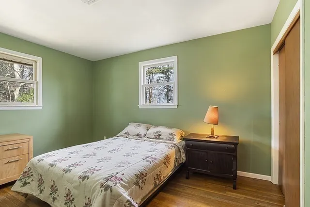 a bedroom with a bed and a lamp on dresser