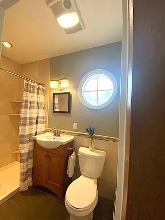 a bathroom with a toilet a sink and mirror