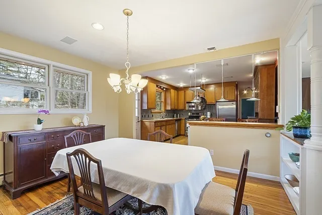 a kitchen with kitchen island a dining table chairs stainless steel appliances and cabinets