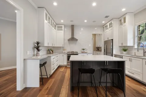 a kitchen with stainless steel appliances a table chairs sink and stove top oven