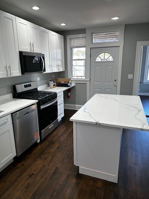 3746 North Whipple Street, Unit 2 Chicago, IL 60618 - Photo 8 of 22 a kitchen with a sink a stove a microwave and wooden floor
