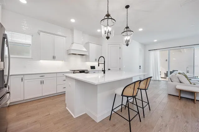 a kitchen with stainless steel appliances granite countertop a sink a stove and a refrigerator