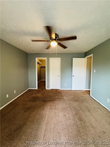 a view of an empty room with window and a ceiling fan