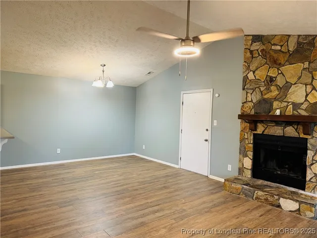 an empty room with fan and fireplace