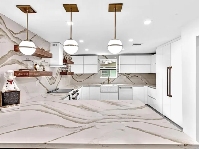 a large kitchen with stainless steel appliances granite countertop a lot of counter space and a sink