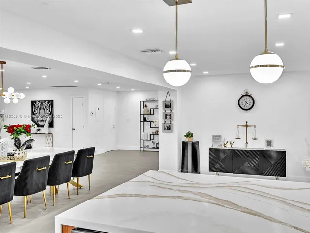 a kitchen with a dining table chairs stainless steel appliances and cabinets