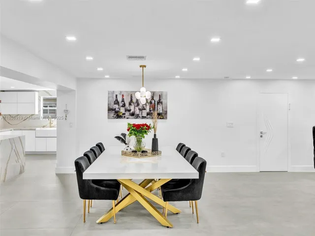 a view of a room with gym equipment and couches with kitchen view