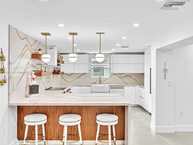 a kitchen with stainless steel appliances granite countertop a sink a stove and a wooden floors