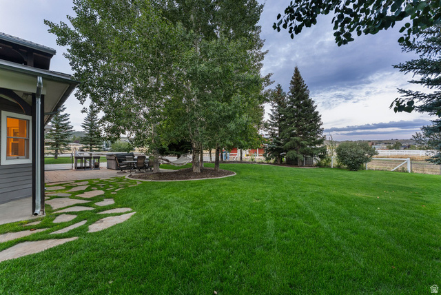 8650 Redden Road Park City, UT 84098 - Photo 41 of 71 Expansive lawn with mature trees and a flagstone pathway leading to a paved patio area