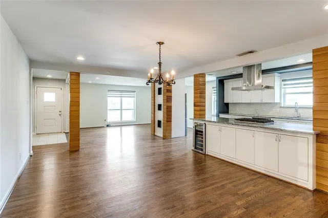 a large kitchen with granite countertop a large counter top space and stainless steel appliances