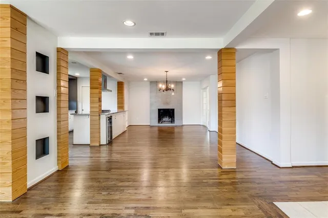 a view of a livingroom with a fireplace wooden floor and windows