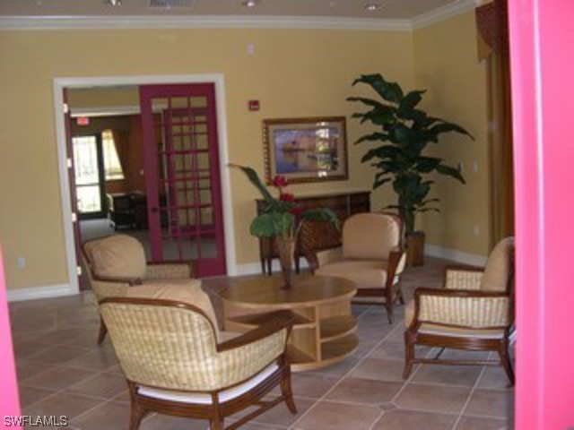 8550 Kingbird Loop Fort Myers, FL 33967 - Photo 4 of 16 a living room with furniture a bookshelf and a potted plant