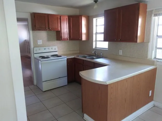 a kitchen with granite countertop a sink stove and refrigerator