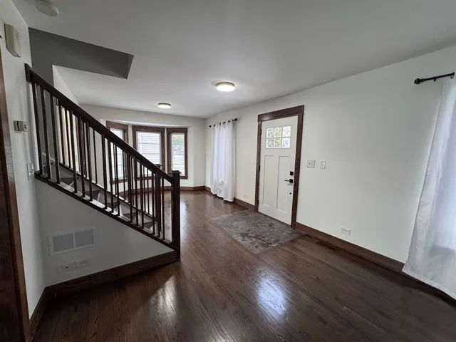 a view of a hallway with wooden floor and stairs