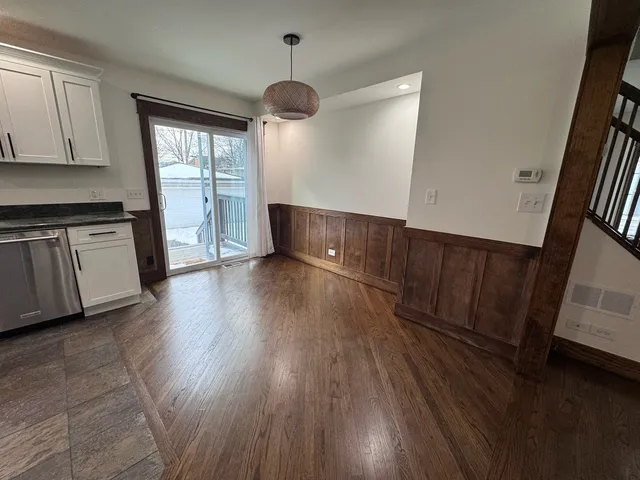 a view of a kitchen with wooden floor and electronic appliances
