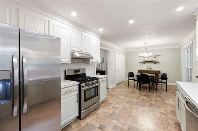 a kitchen with kitchen island granite countertop a refrigerator stove microwave and cabinets