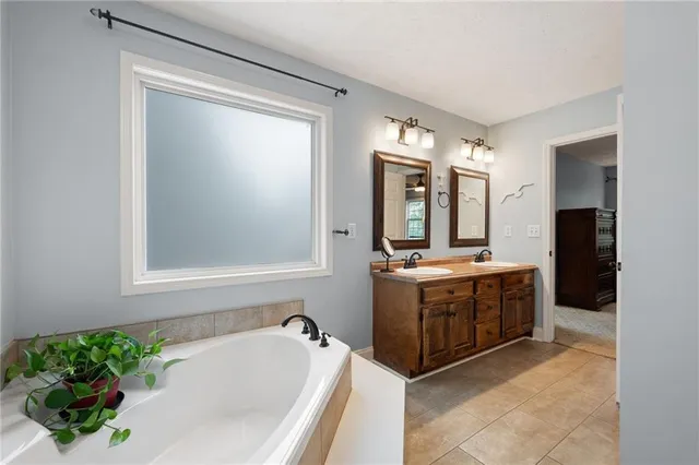 a bed sitting in a spacious bedroom next to a window