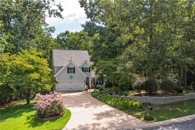a aerial view of a house with a yard and large trees