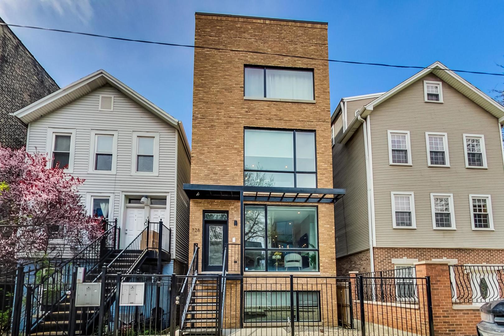 728 North Elizabeth Street, Unit 1 Chicago, IL 60642 - Photo 1 of 27 a view of a brick house with large windows and a small yard
