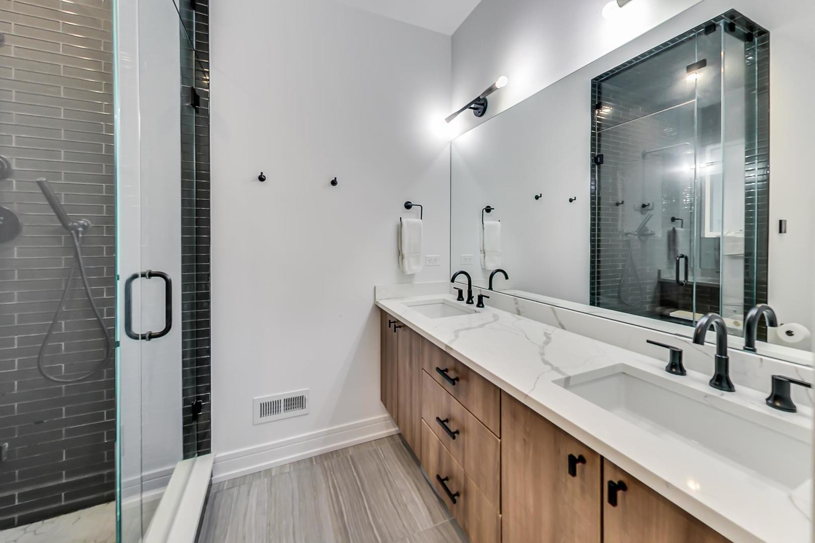 728 North Elizabeth Street, Unit 1 Chicago, IL 60642 - Photo 12 of 27 a bathroom with a double vanity sink a mirror and shower