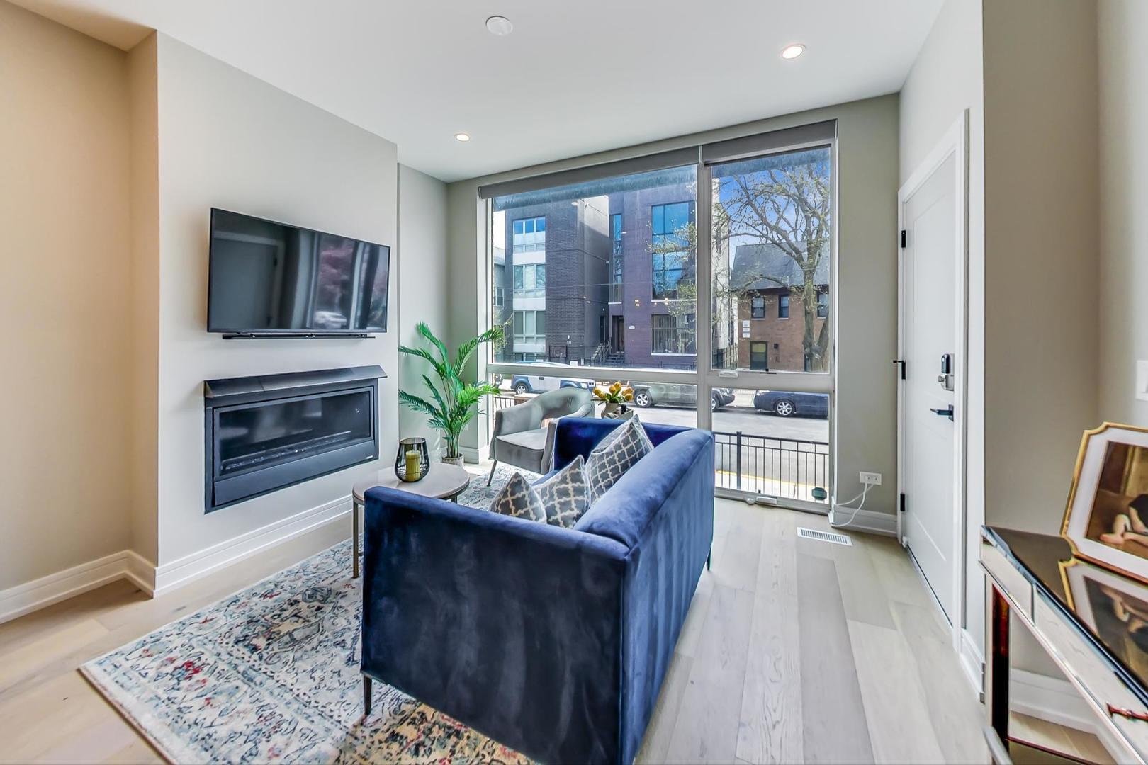 728 North Elizabeth Street, Unit 1 Chicago, IL 60642 - Photo 2 of 27 a living room with furniture and a fireplace